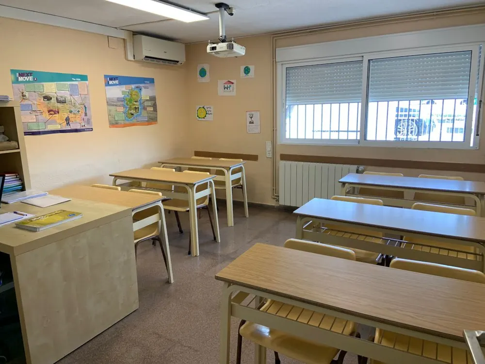 Aula luminosa de Brigsol con mapas y pupitres